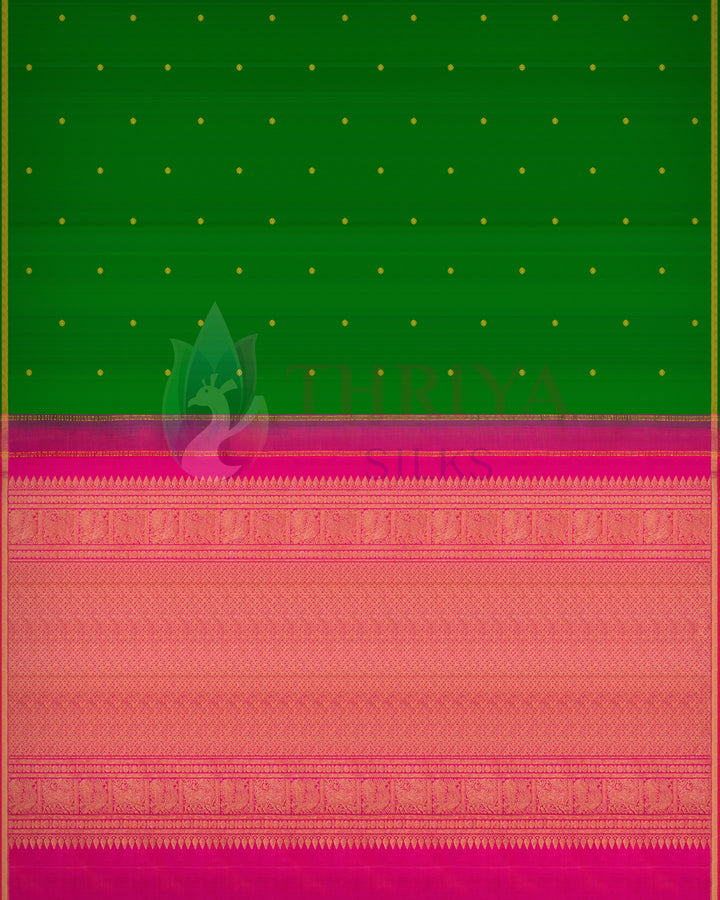 Green Kanchipuram silk saree with small gold buttas and rich pink zari pallu