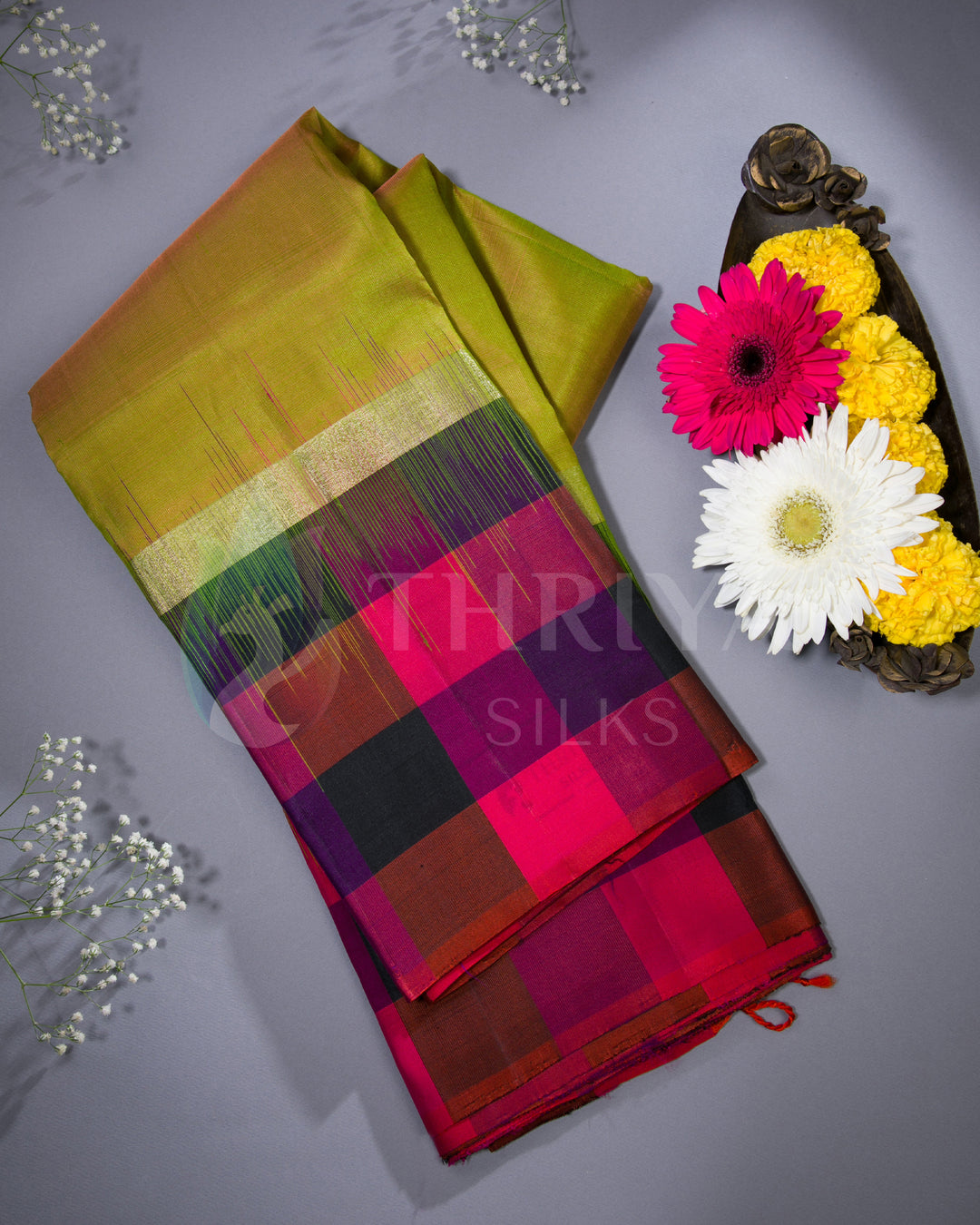 Lime green silk saree with bold checkered border and pink pallu styled with flowers