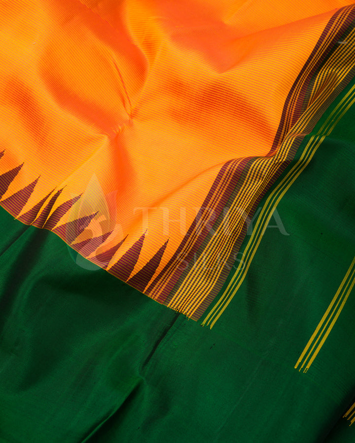 Close-up of green and orange silk saree fabric and detailed border work, Thriya Silks