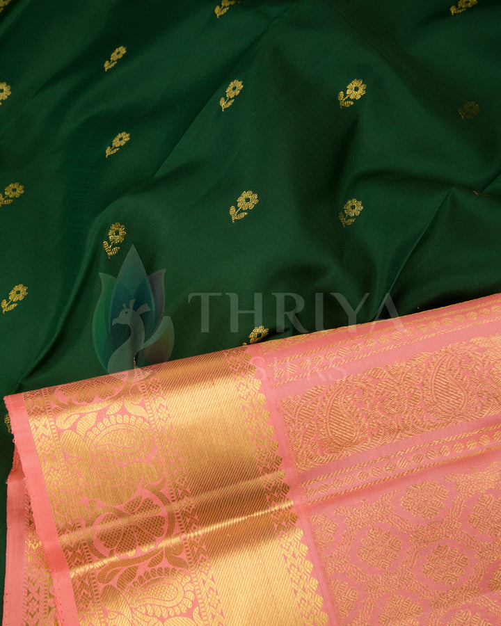 Detailed view of green silk fabric with delicate gold motifs and peach zari border by Thriya