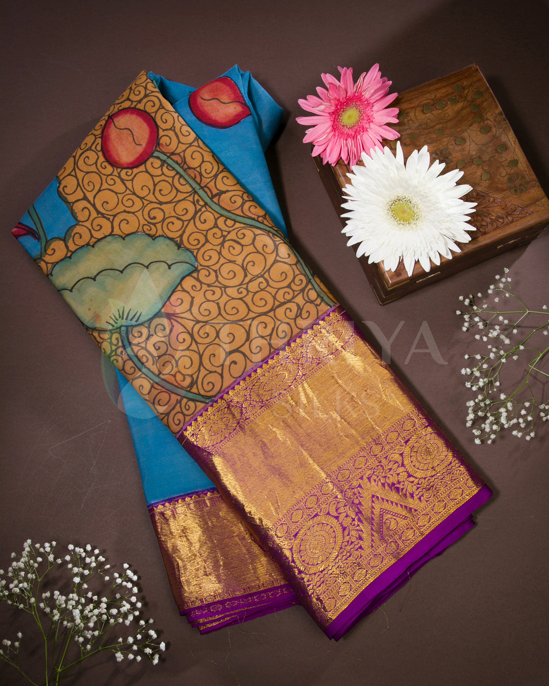 Folded view of blue Kalamkari silk saree with mermaid and lotus motifs and purple zari border