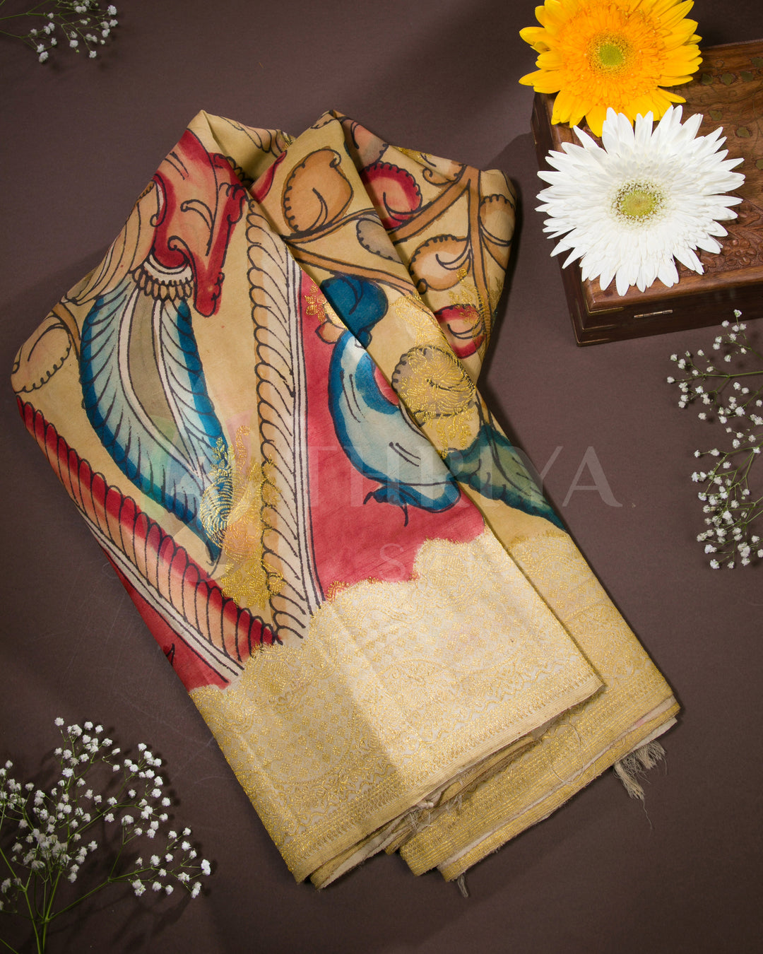 Golden silk saree with hand-painted Kalamkari peacock and floral motifs - front view.