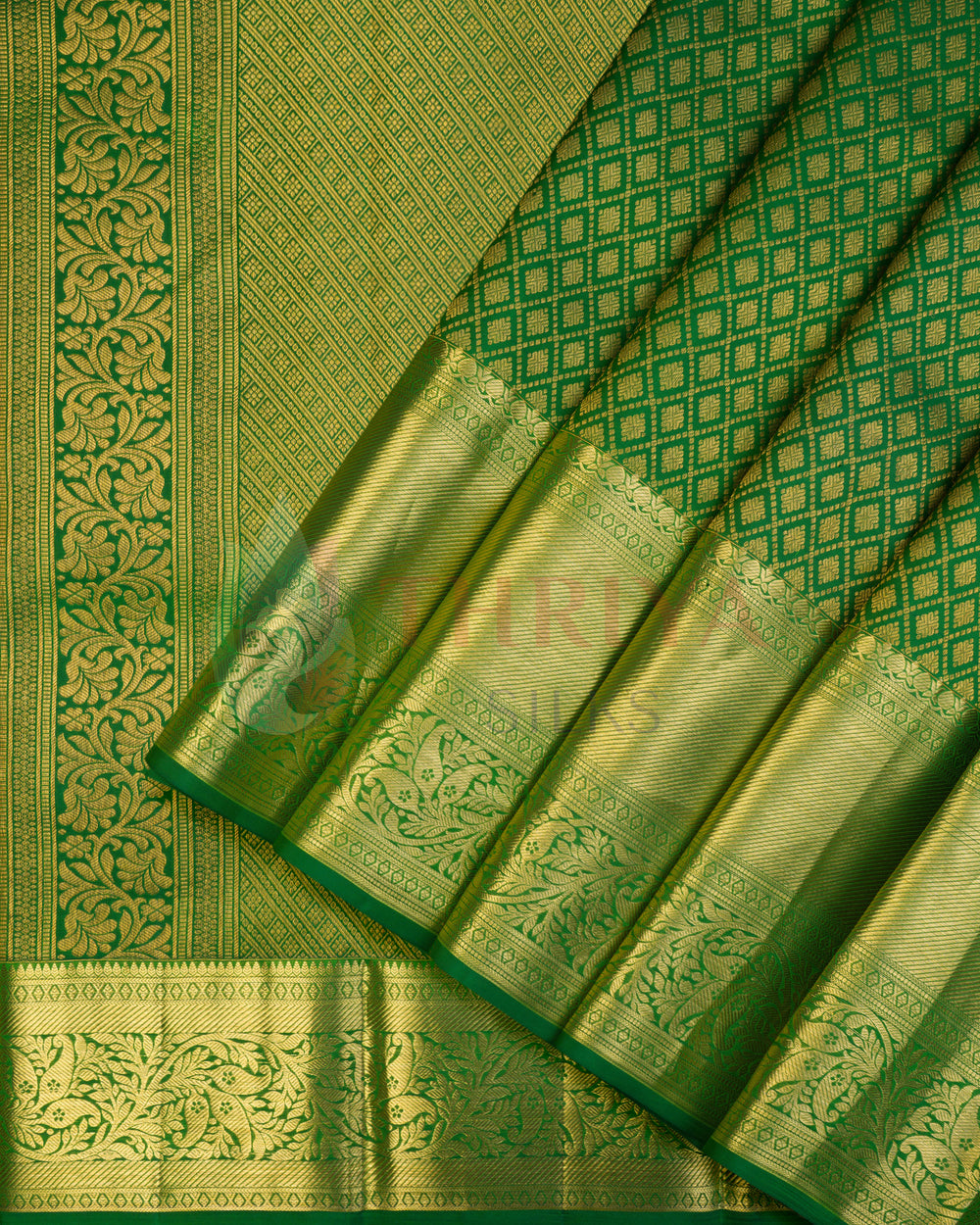Folded green Kanchipuram silk saree with gold zari border and diamond pallu design