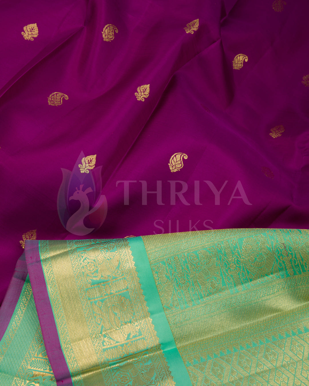 Detailed angle showing pleats and pallu of purple silk saree with contrasting green zari border