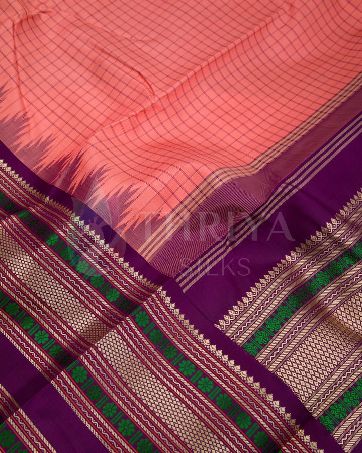 Close-up of peach Kanjivaram silk saree with checked pattern and purple green zari border