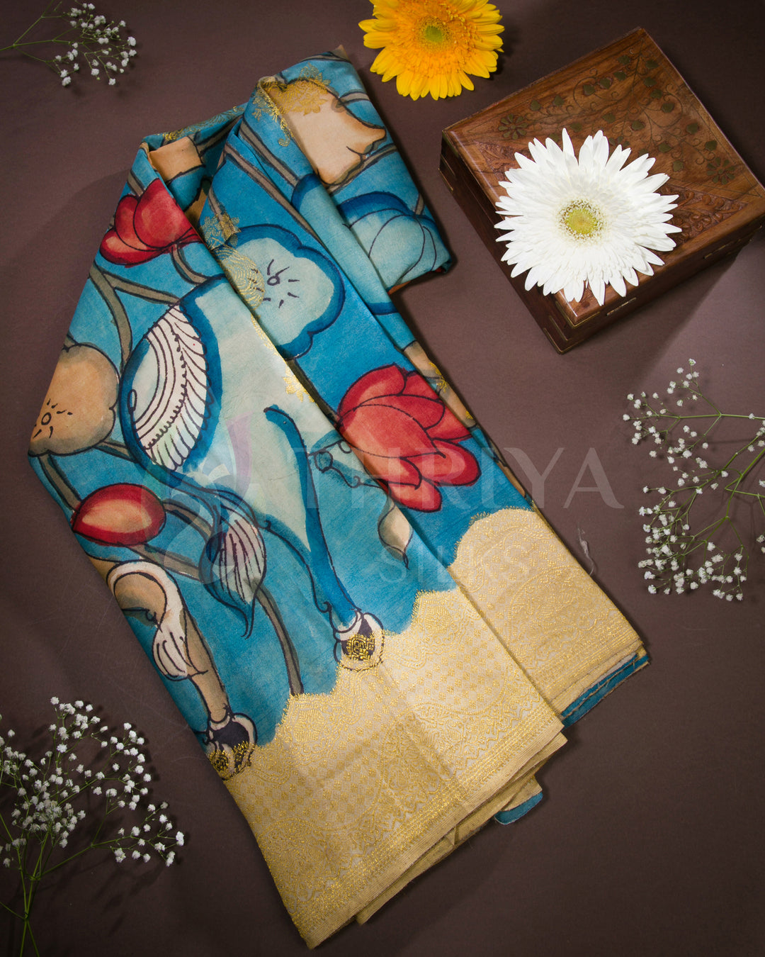  Folded view of sky blue Kalamkari silk saree with hand-painted animal and floral motifs and gold zari border