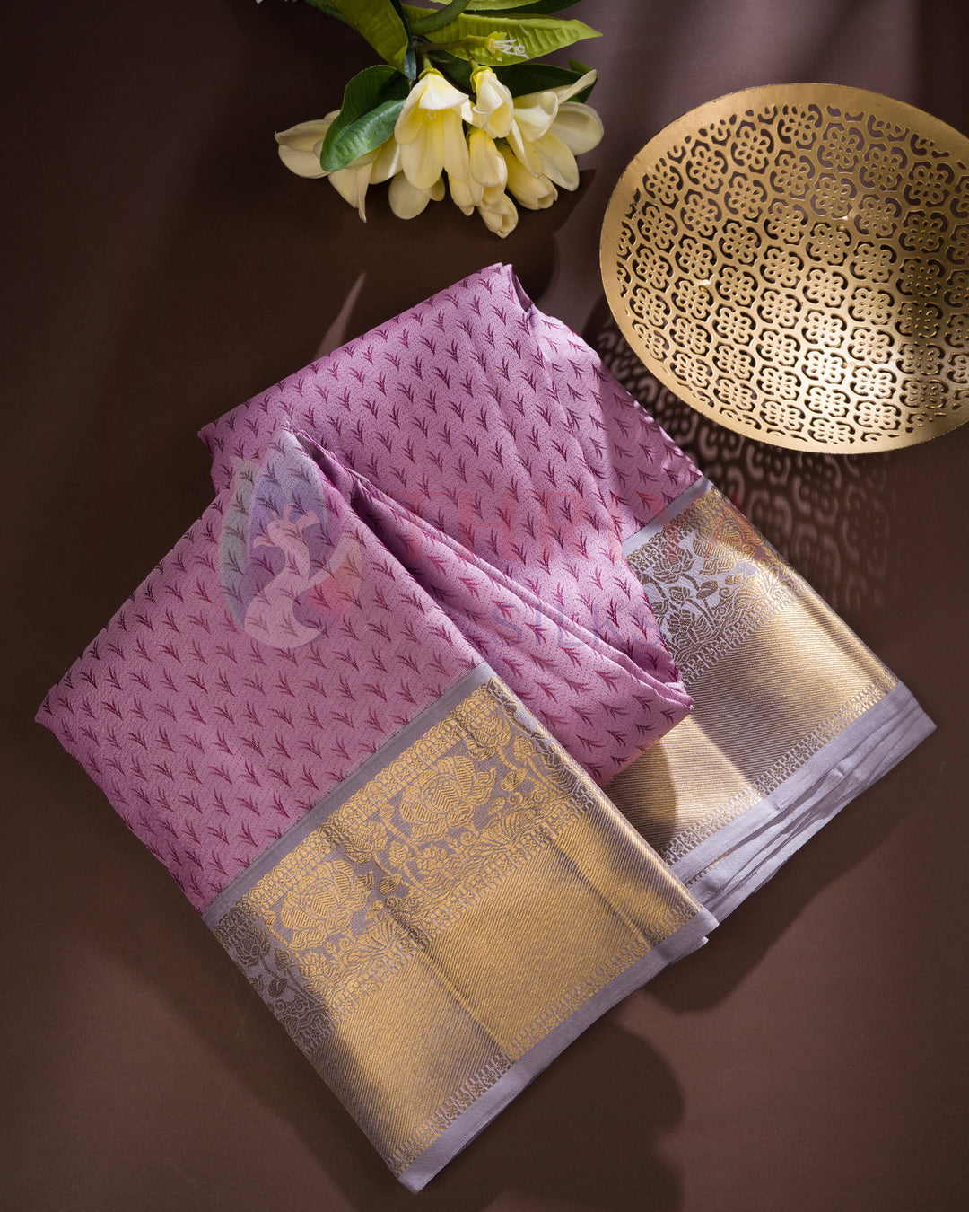 Folded lavender Kanjivaram silk saree with intricate gold zari work