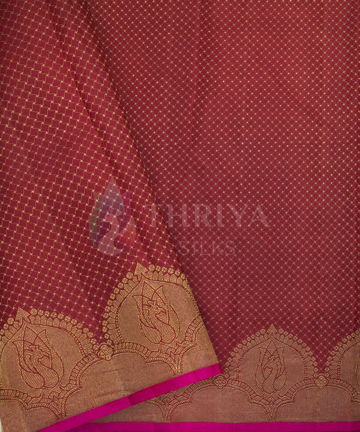 Elegant maroon Kanchipuram silk saree adorned with diagonal gold zari buttas and a scalloped borde