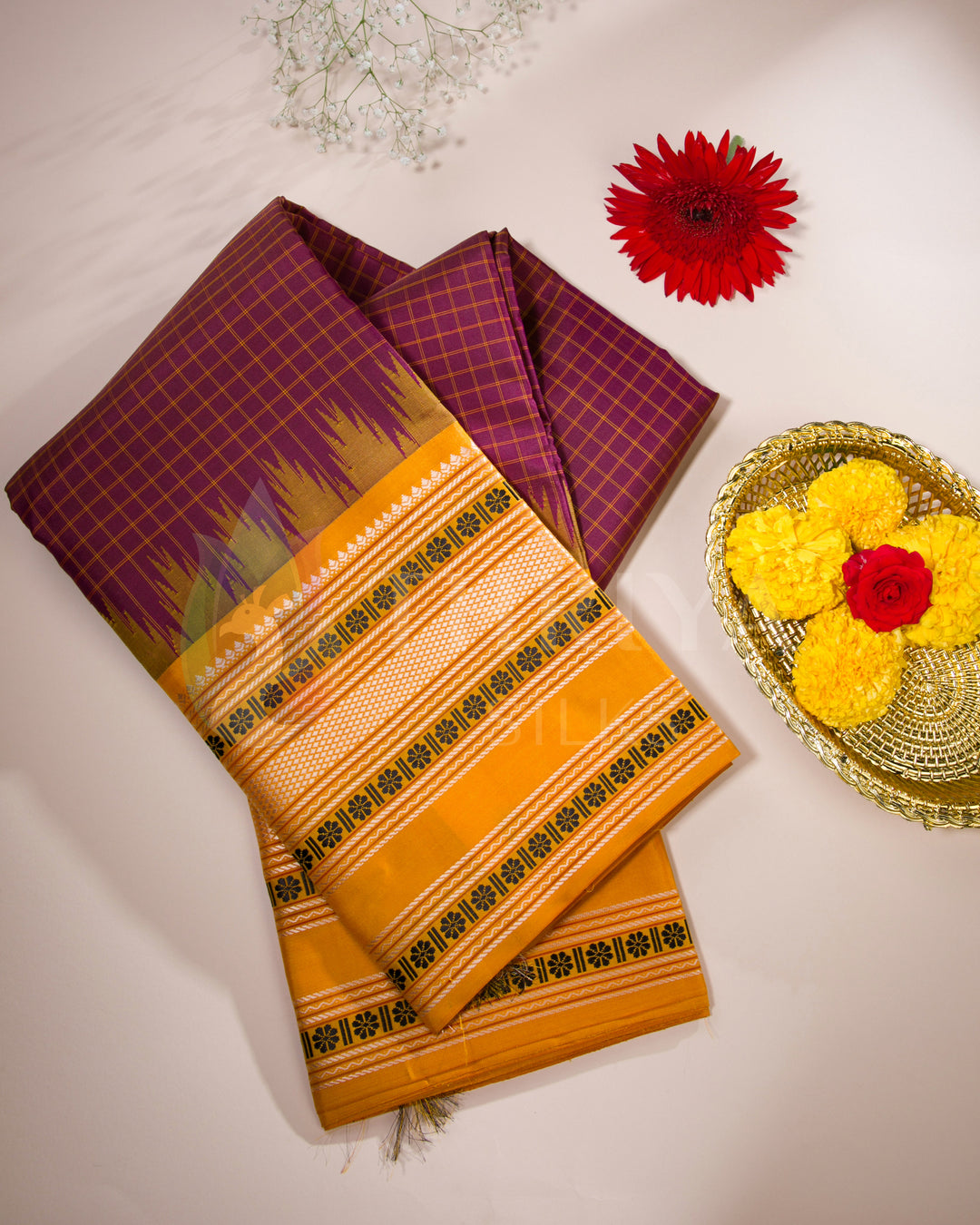 Maroon and mustard yellow silk saree styled with flowers and gold accessories for festive vibes