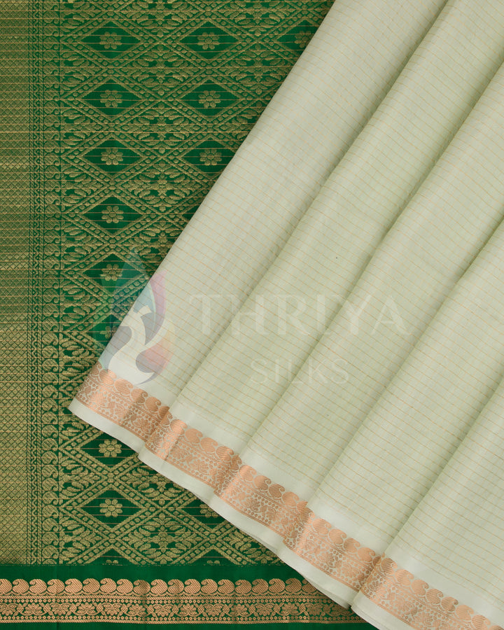 Off-white Kanjivaram silk saree with rich green zari pallu and gold woven border