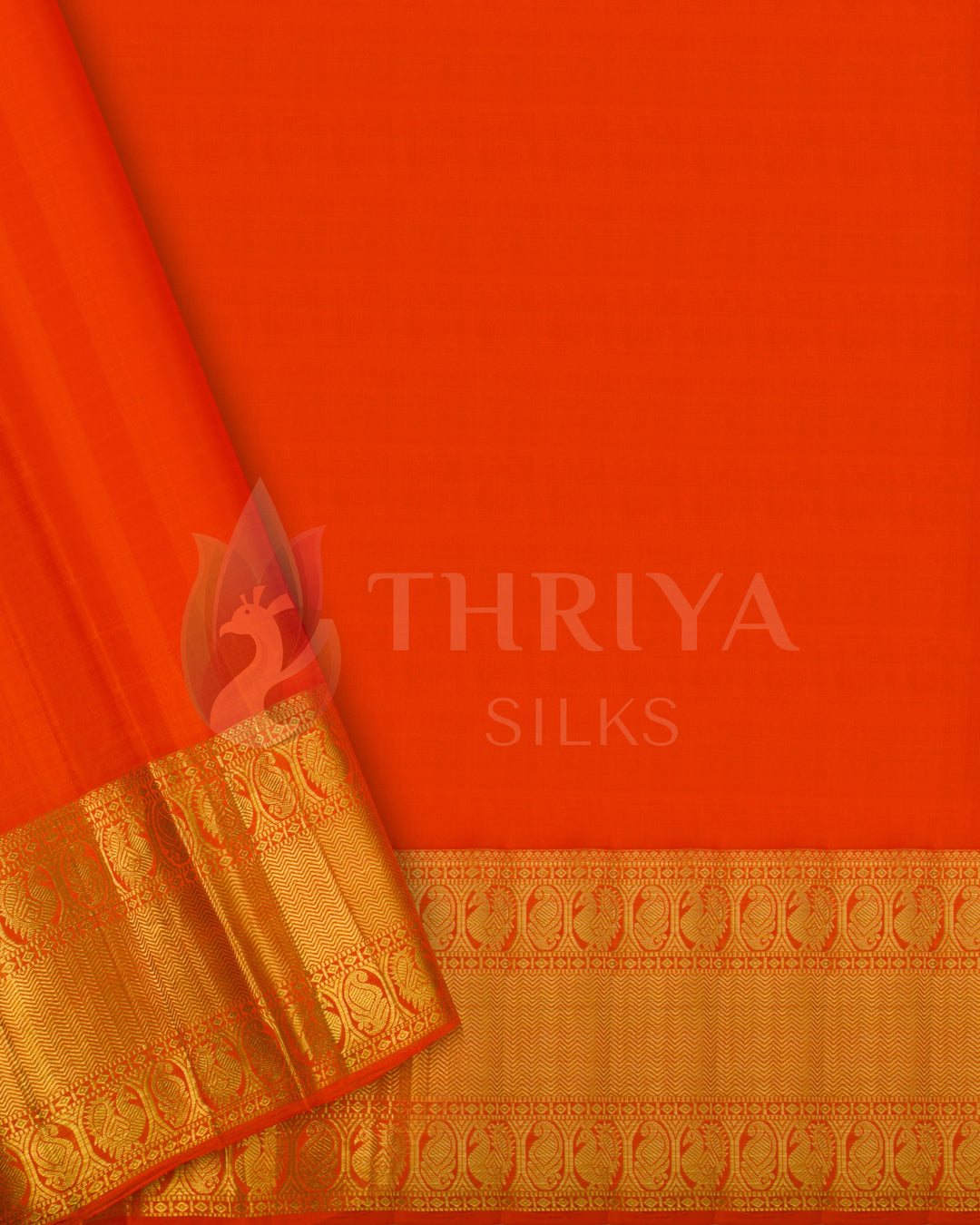 Plain orange blouse piece with gold zari border, complementing the pink bird and lotus motif silk saree.