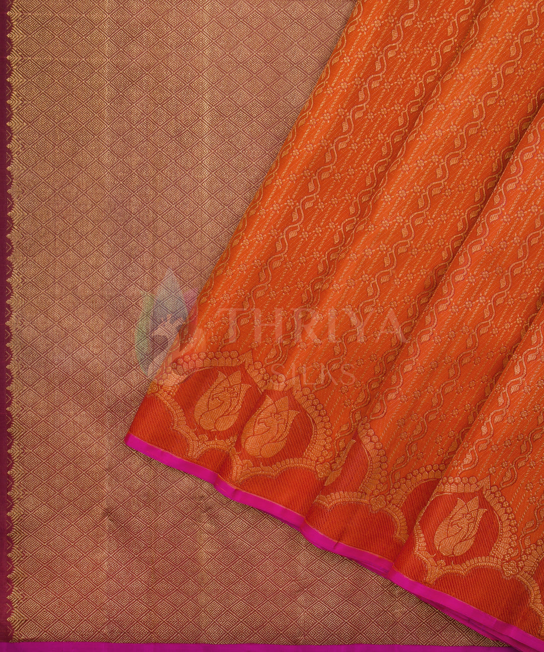 Vibrant orange Kanchipuram saree with bold golden motifs and rich zari detailing along the border.