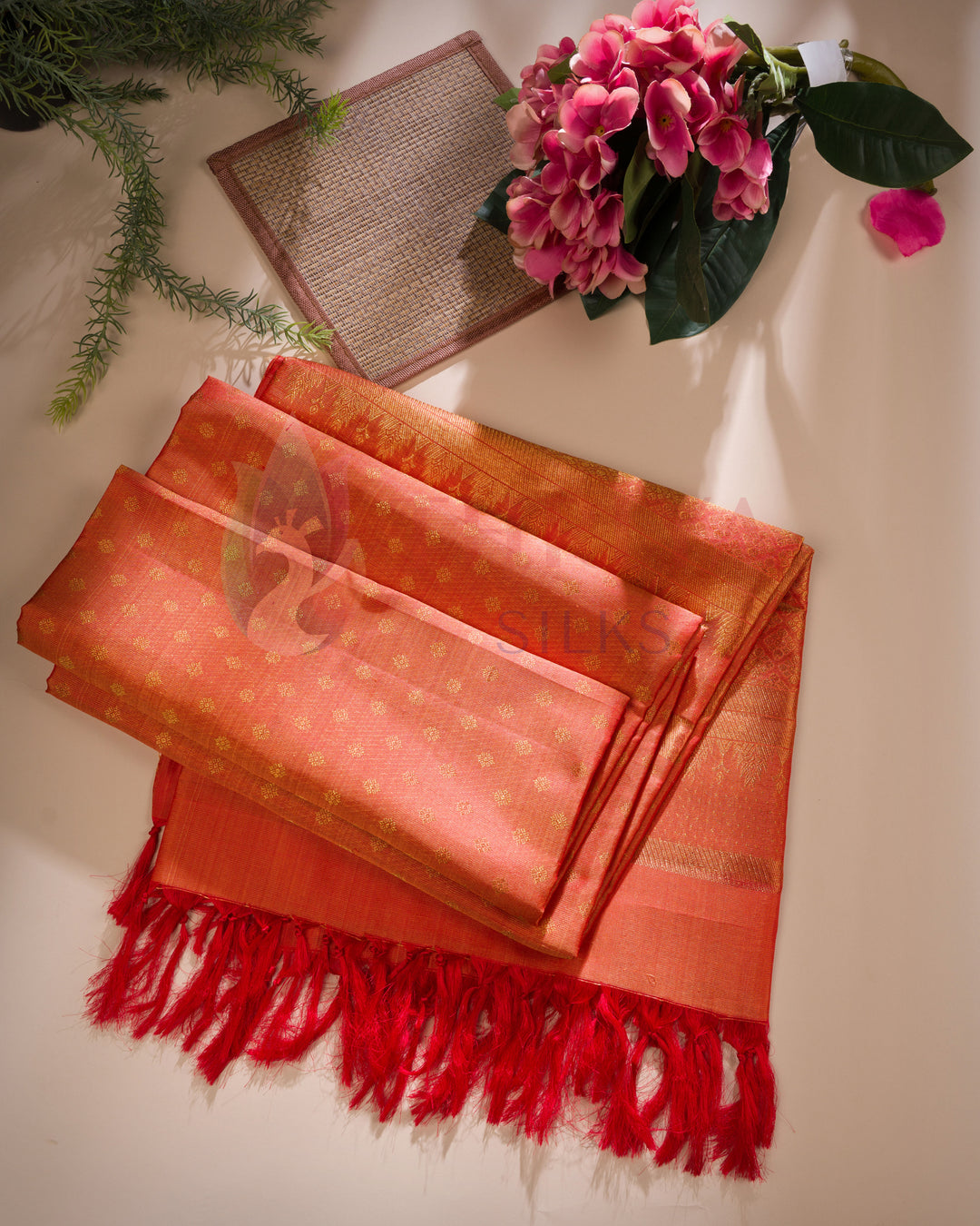 Orange silk dupatta with gold woven motifs and bright red tassel edging