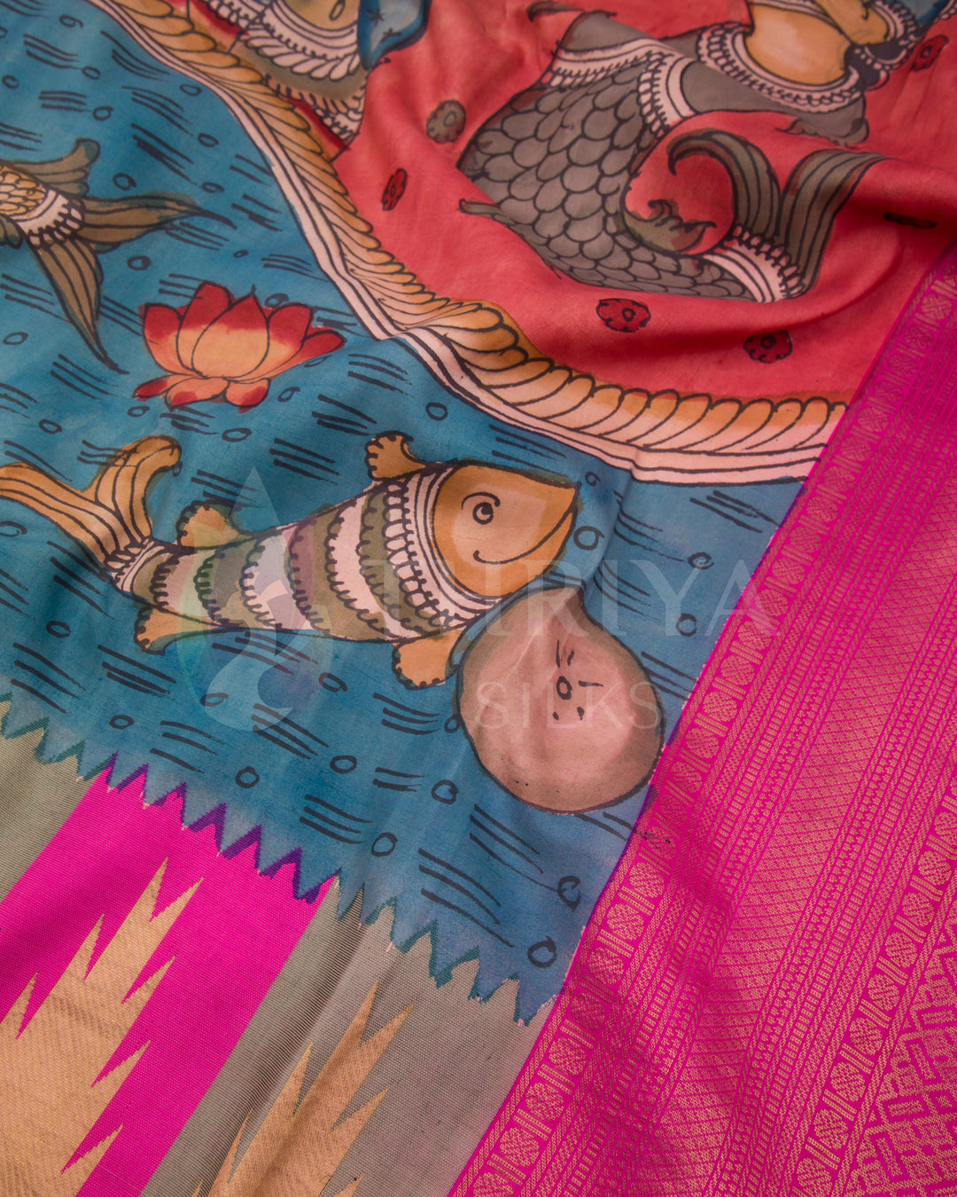 Detailed view of golden zari border with fish motifs and Kalamkari deity painting on pink and blue silk saree.