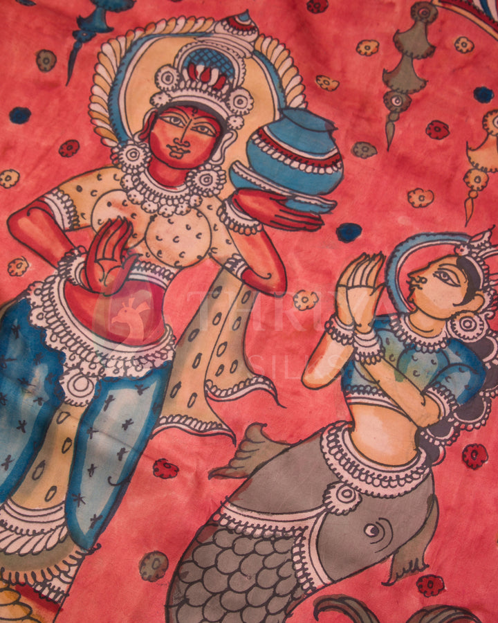 Close-up of hand-painted deity motifs in traditional Kalamkari style on pink silk fabric.