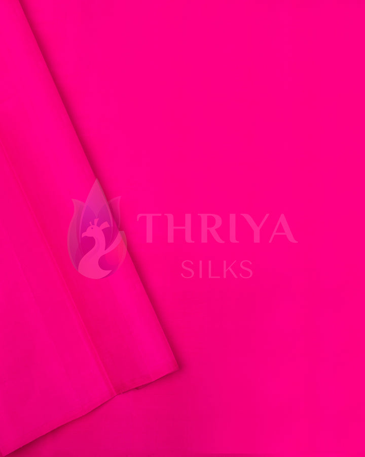 Plain bright pink blouse piece designed to complement the royal blue Banarasi silk saree.