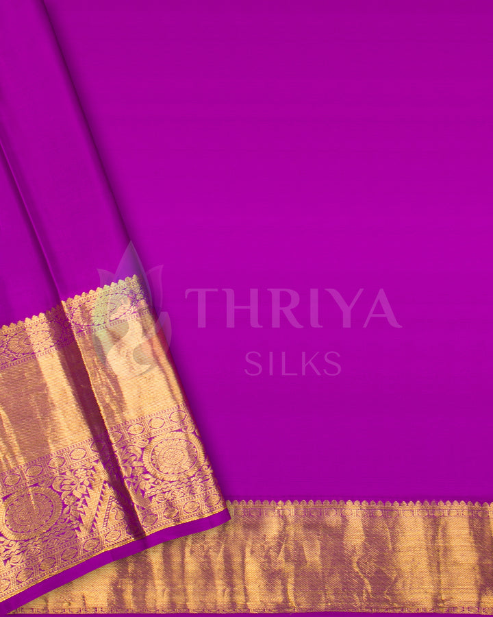 Elegant plain magenta silk saree featuring rich golden zari border and intricate pallu design.