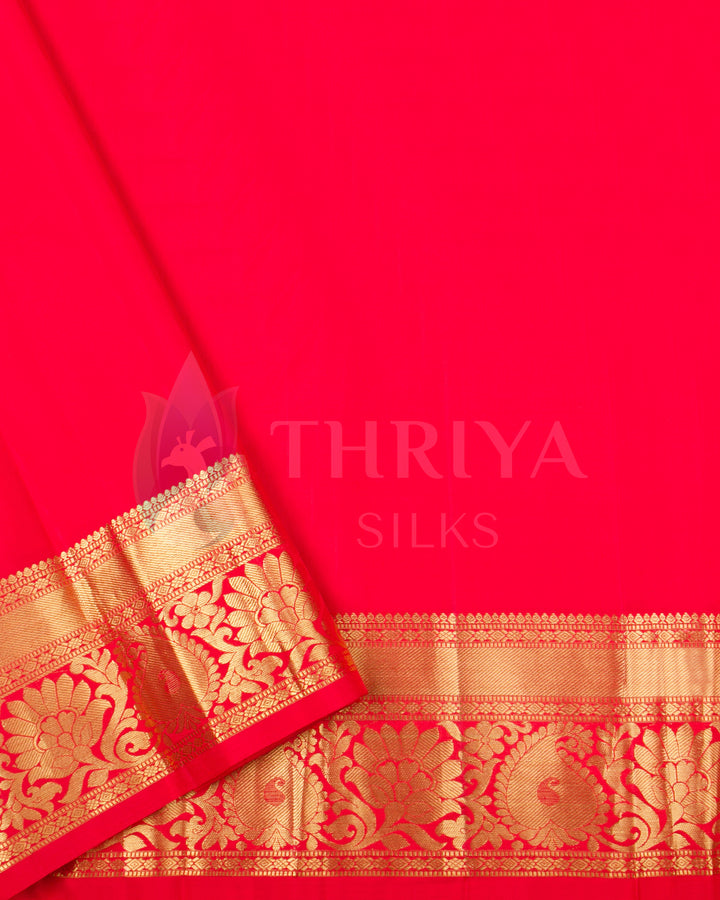 Plain red blouse piece with a traditional gold zari border, complementing the blush pink saree.