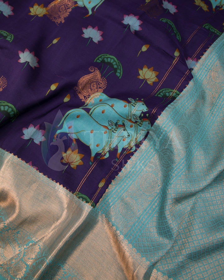 Close-up view of blue elephant motif and silver zari border on rich purple silk base