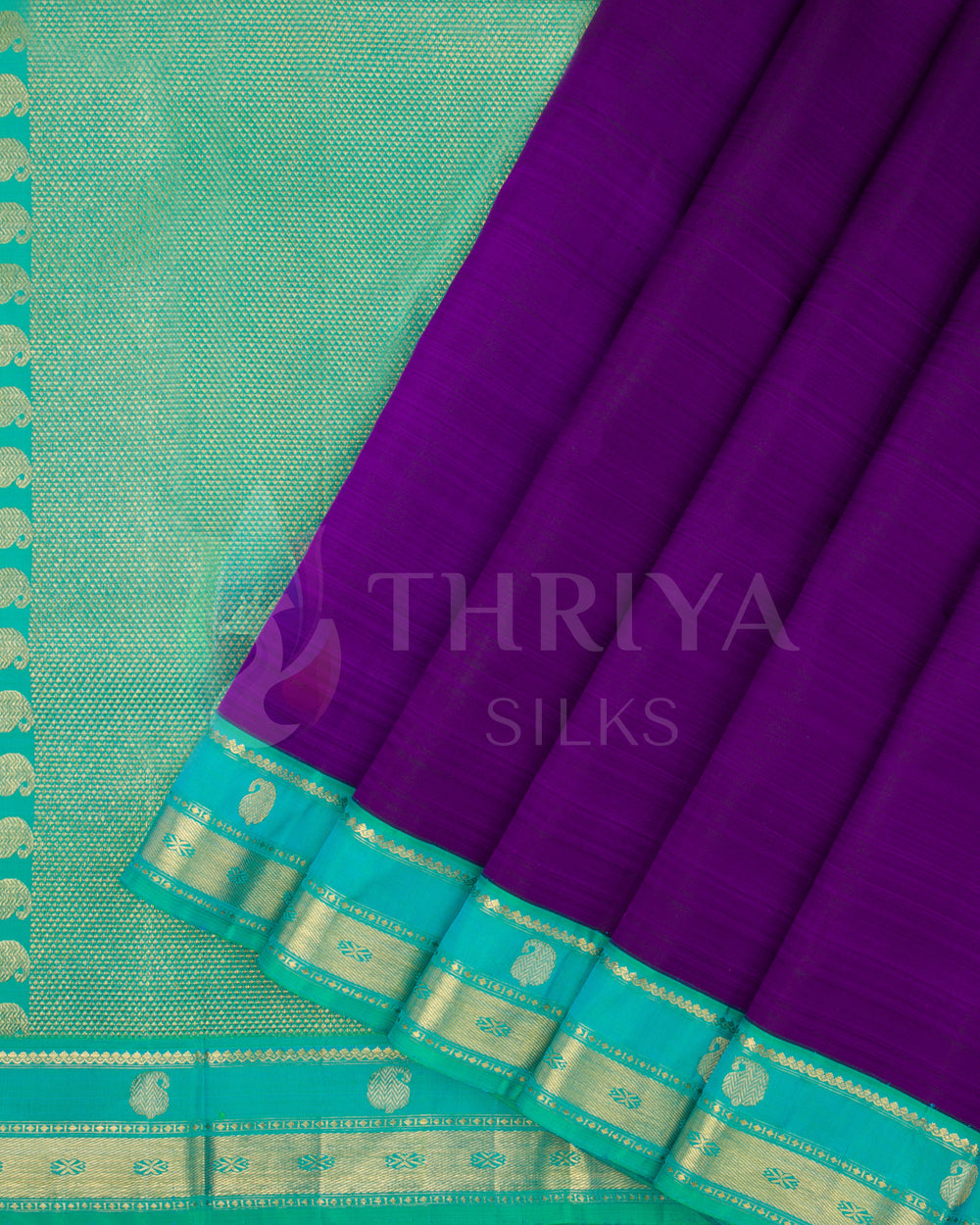 Pleats of deep purple silk saree with aqua blue border and intricate gold zari design