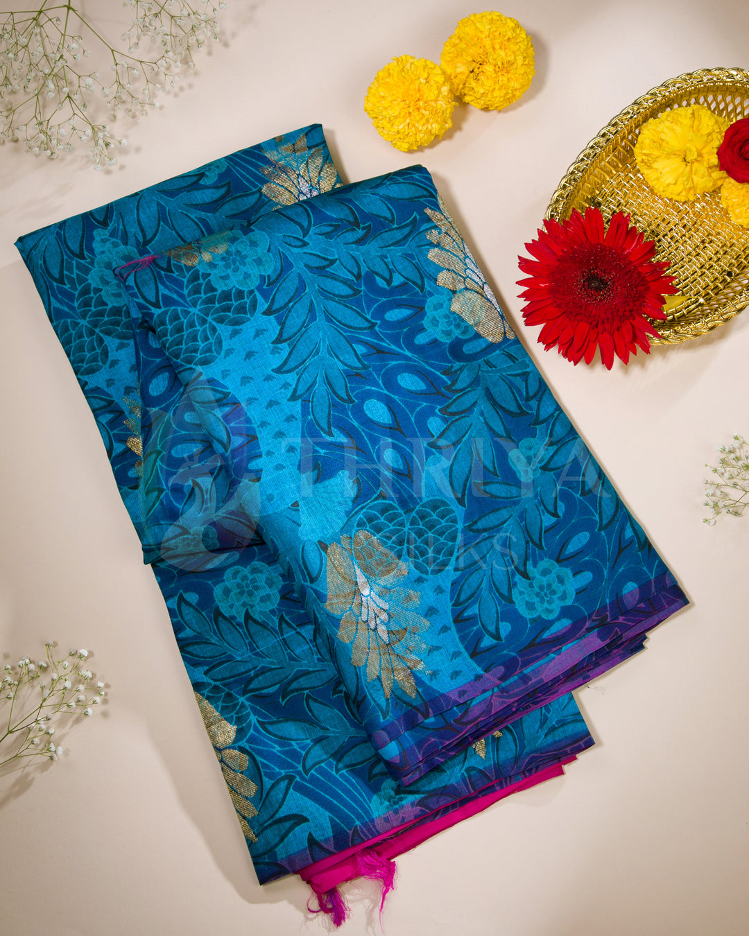Folded view of royal blue Banarasi silk saree featuring intricate floral zari patterns with pink highlights.