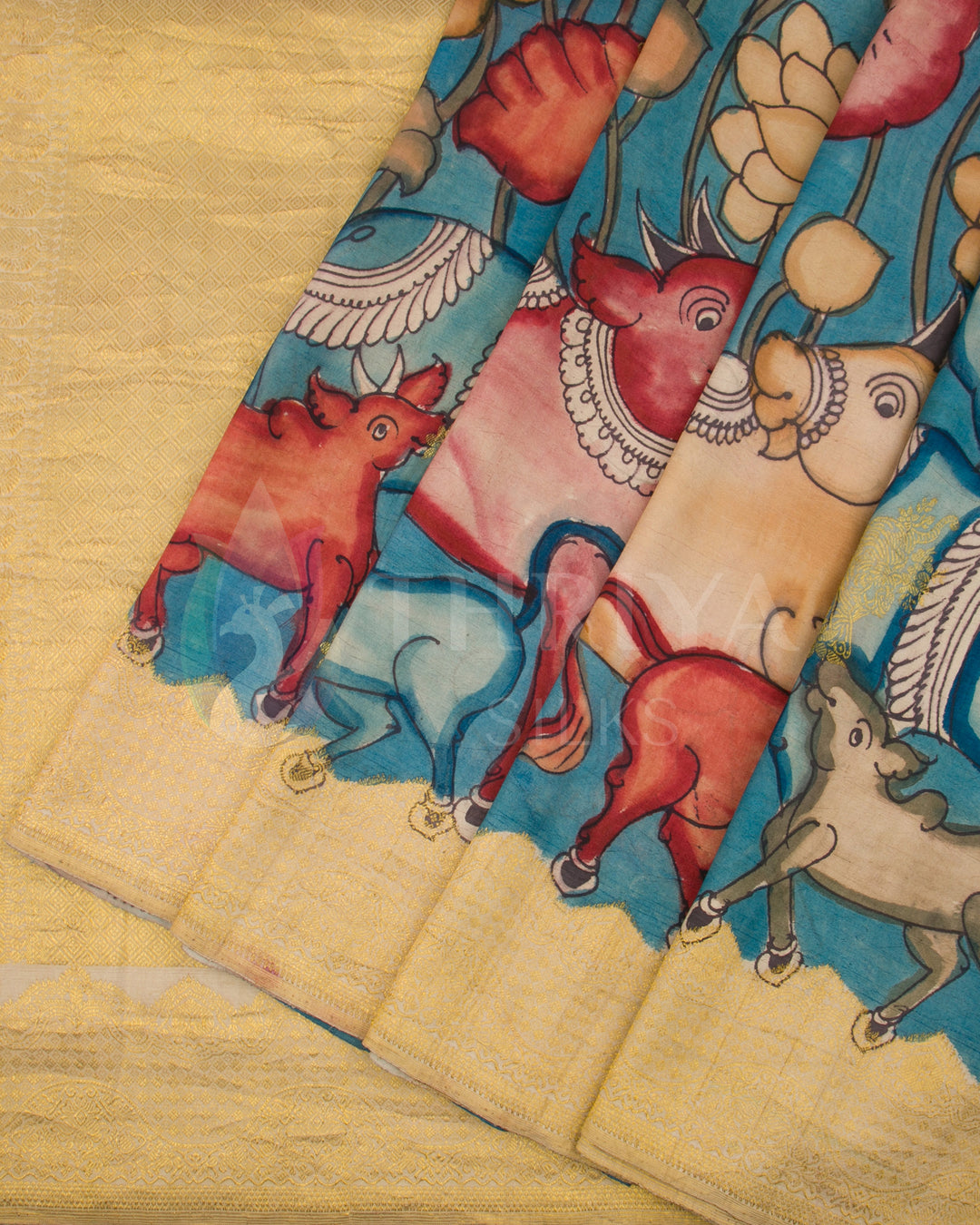 Close-up of pleats showing vibrant animal and floral Kalamkari designs on sky blue silk saree