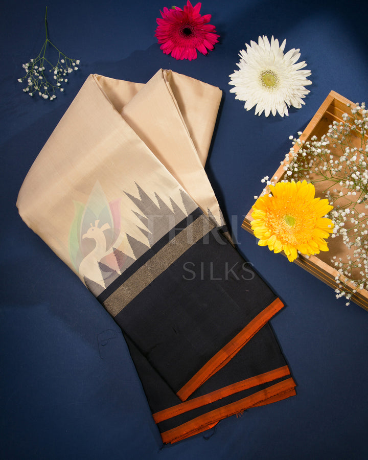 Styled view of beige and black temple border silk saree with floral props