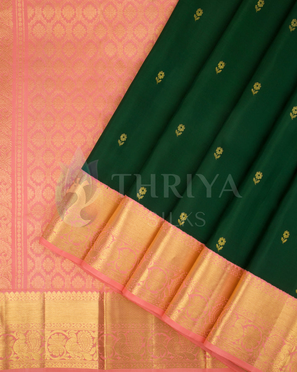 Dark green silk saree with peach-pink border and gold zari pleats by Thriya Silks