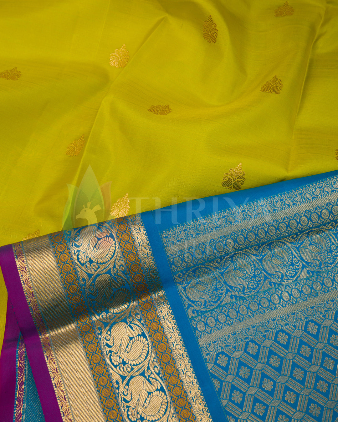 Close-up of lime yellow silk fabric with gold motifs and detailed blue zari border by Thriya
