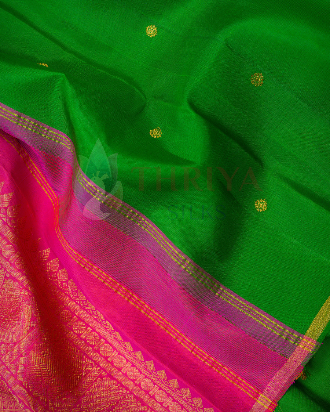 Vibrant Kanchipuram saree with deep green body, gold buttas, and grand pink pallu