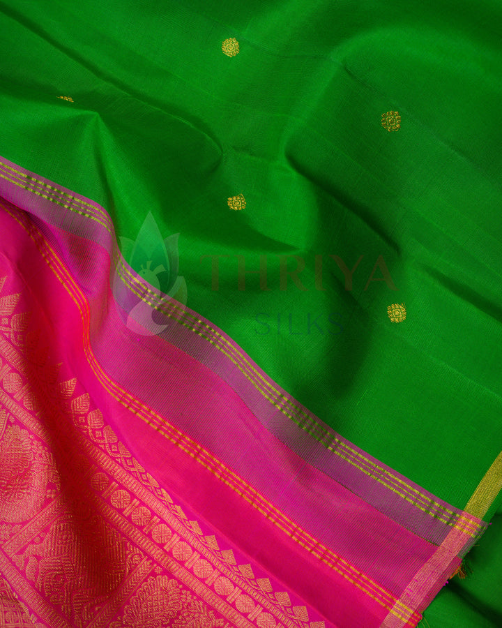 Vibrant Kanchipuram saree with deep green body, gold buttas, and grand pink pallu