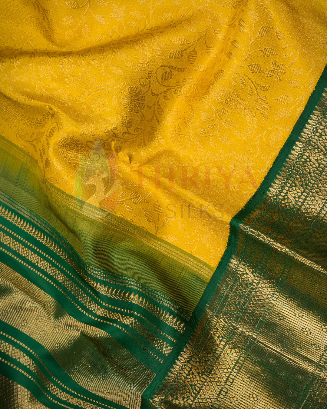 Close-up of yellow Kanjivaram silk saree with intricate green and gold zari work – Thriya Silks design