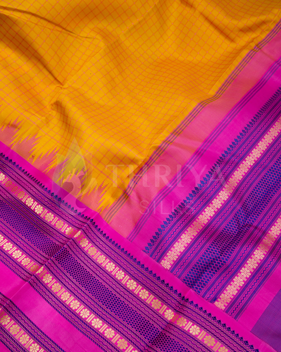  Close-up view of yellow Kanjivaram silk saree with pink and royal blue zari border