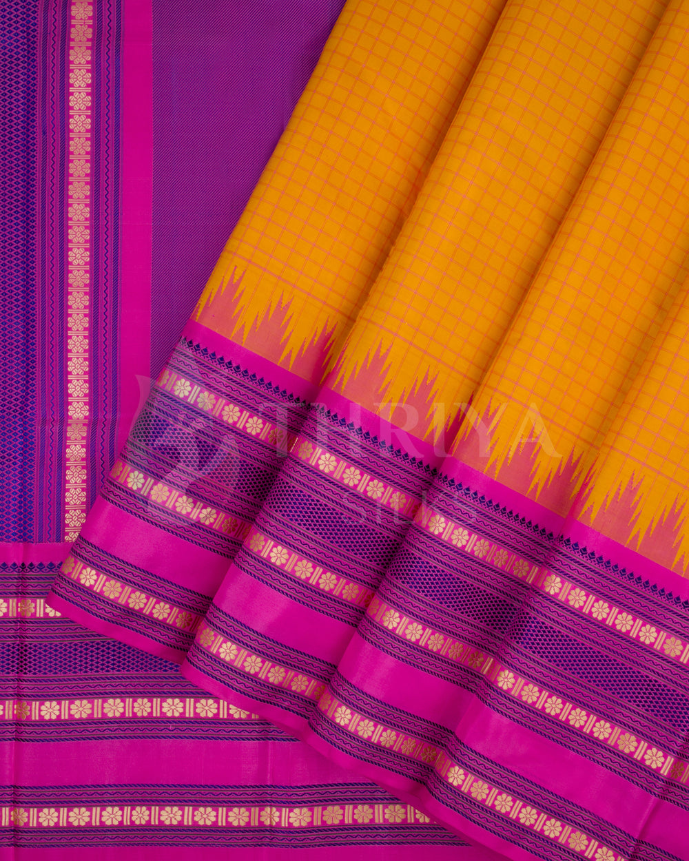 Yellow Kanjivaram silk saree with vibrant pink zari border and intricate pleats