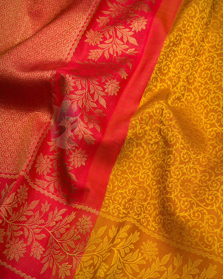 Close-up view of yellow Kanjivaram silk saree with red pallu and golden zari floral motifs – premium bridal silk saree 