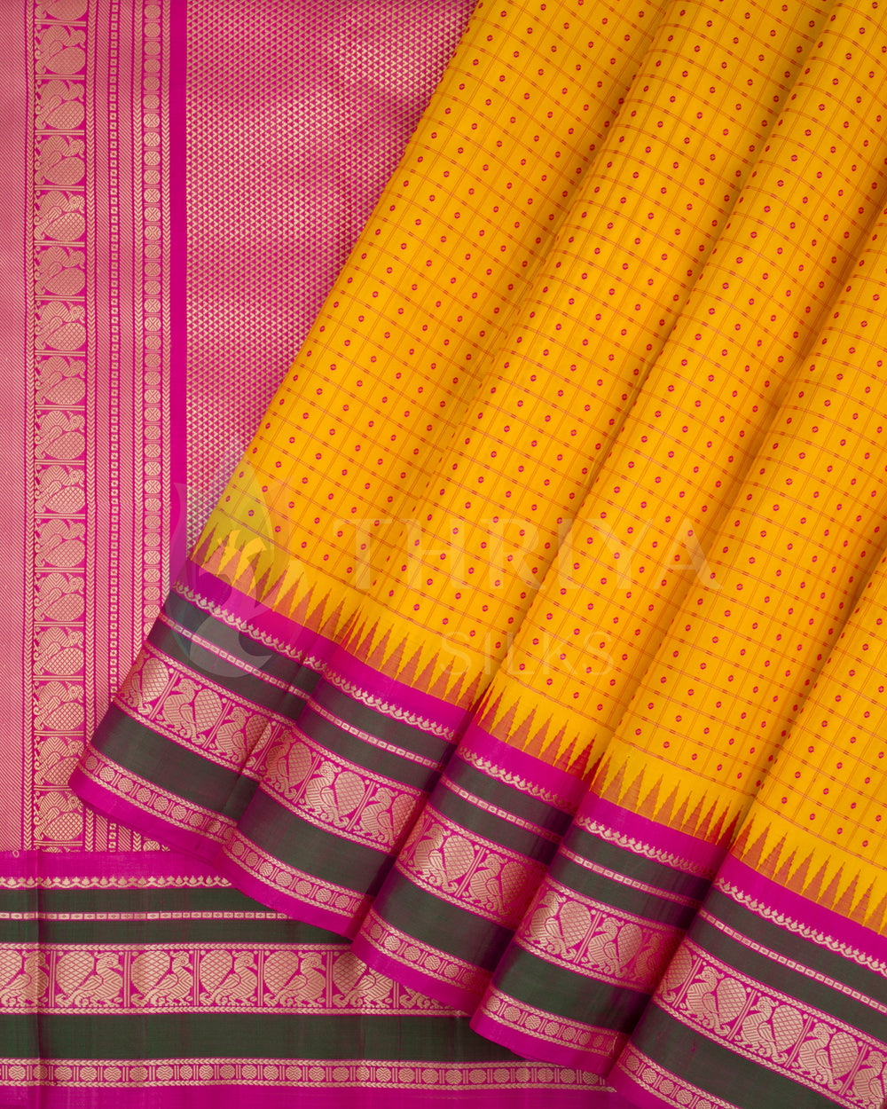 Yellow soft silk saree with pink and gold zari border shown in pleated style