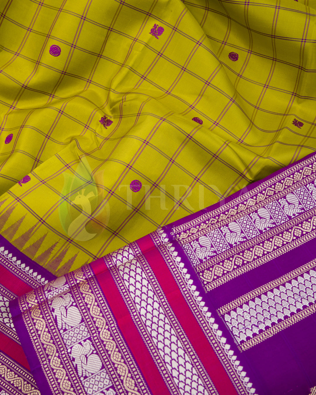 Close-up of yellow body with small woven buttas and intricate magenta zari pallu from Thriya Silks