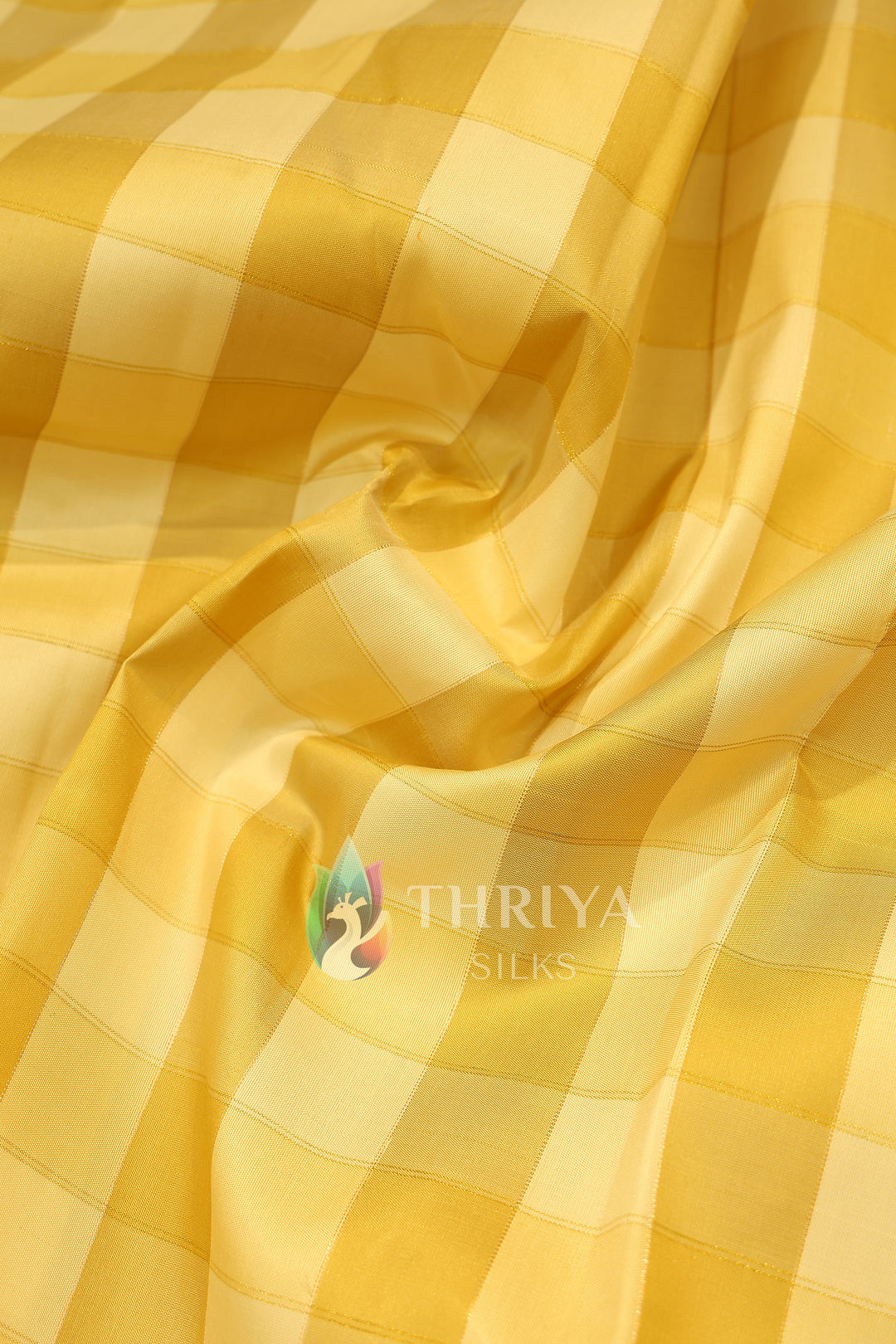  Soft silk saree with glossy yellow checkered body and smooth drape.
