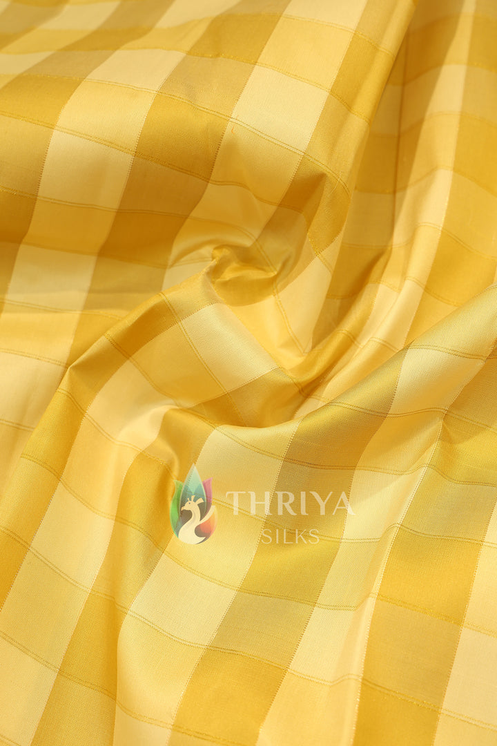  Soft silk saree with glossy yellow checkered body and smooth drape.