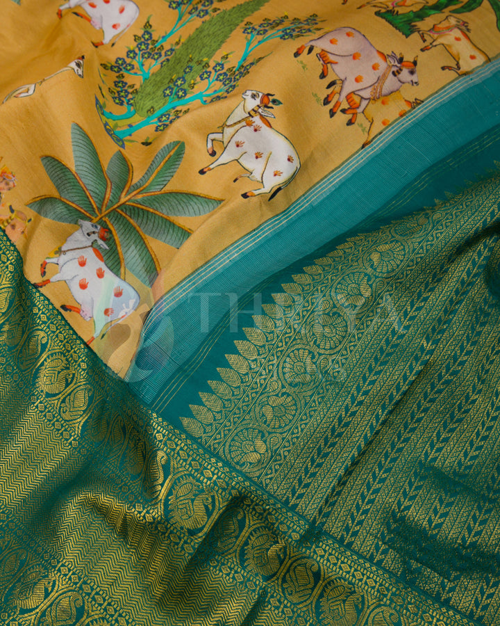  Detailed view of green zari pallu and mustard body with vibrant cow and foliage motifs.